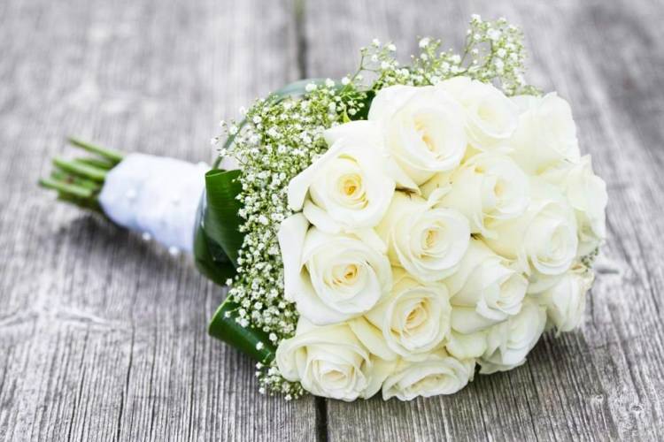 Букет невесты из белых роз и гипсофилы.